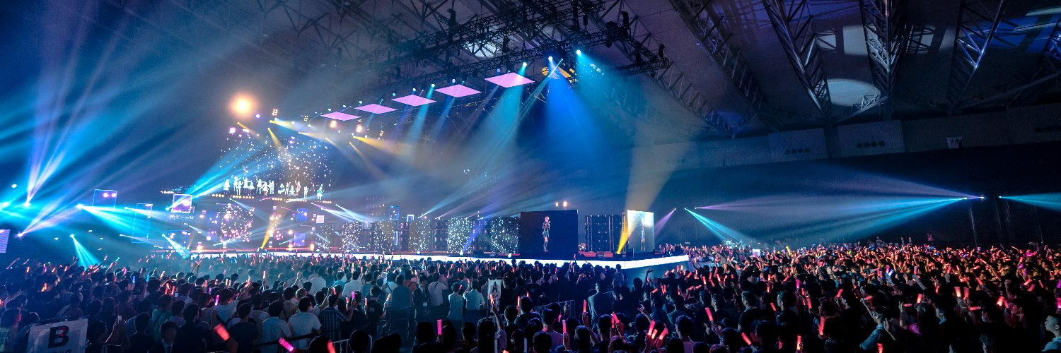 光の演出に包まれたライブステージと会場の観客